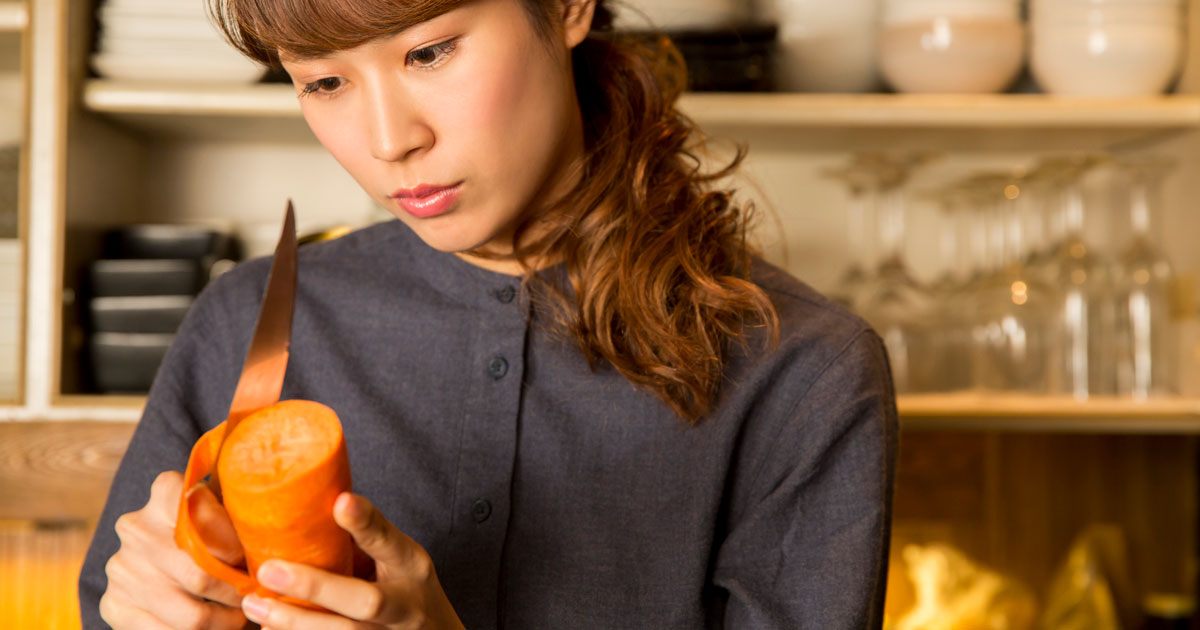 野菜の皮をむく女性