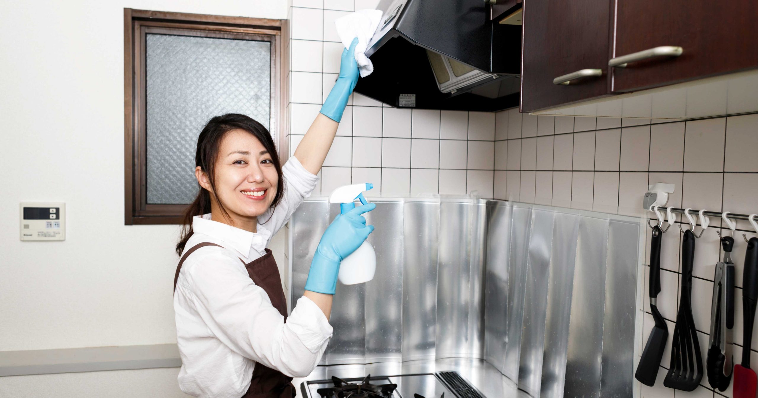 キッチンの換気扇を掃除する女性の写真