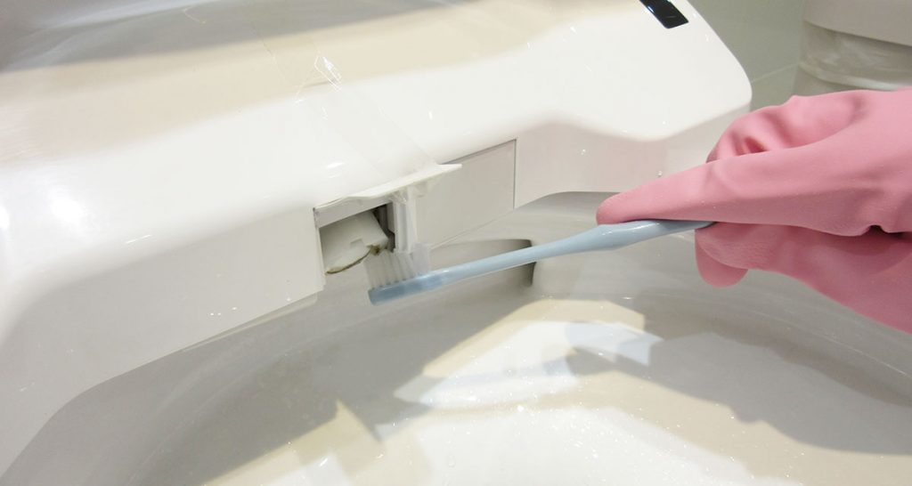 ノズル収納口を古歯ブラシで掃除する写真