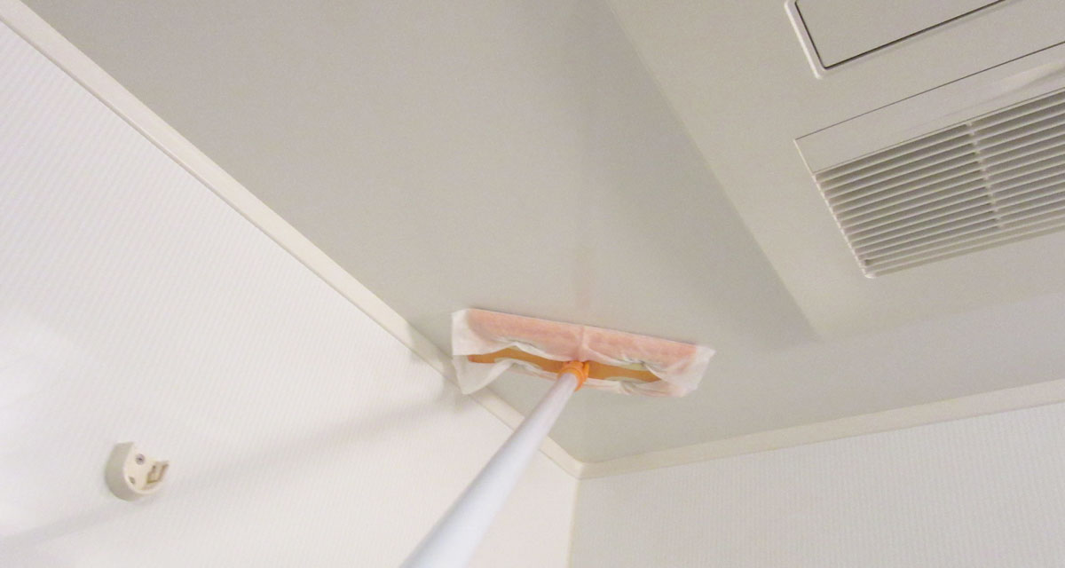 除菌水を浸した掃除シートで天井を掃除する様子