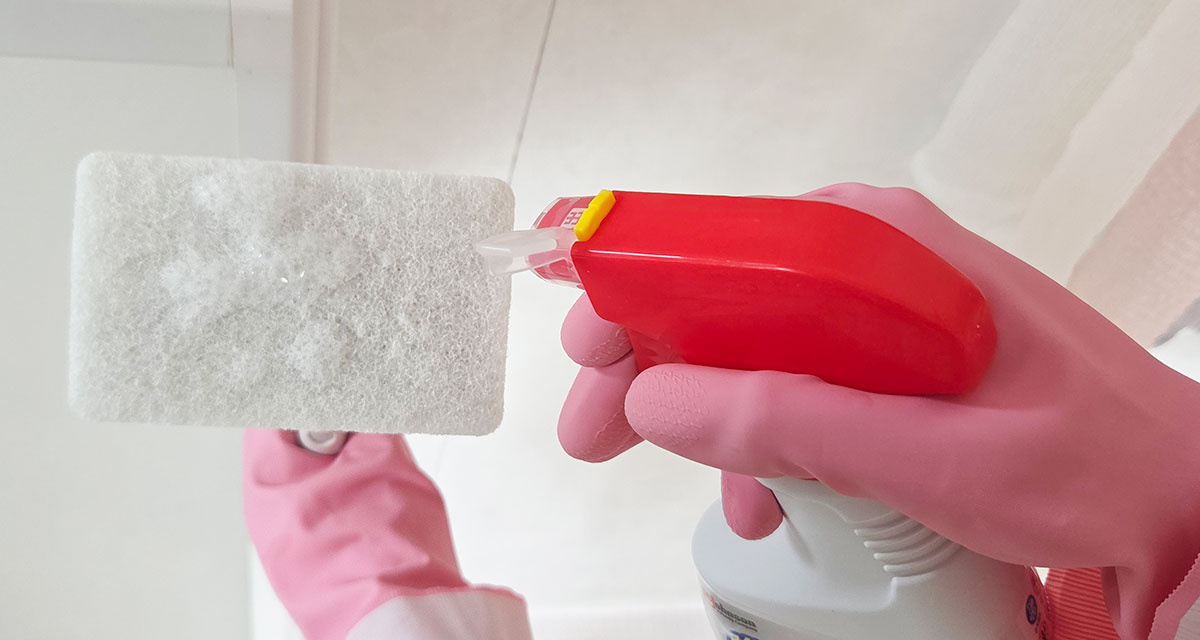 柄付きスポンジにカビキラーをかけている写真