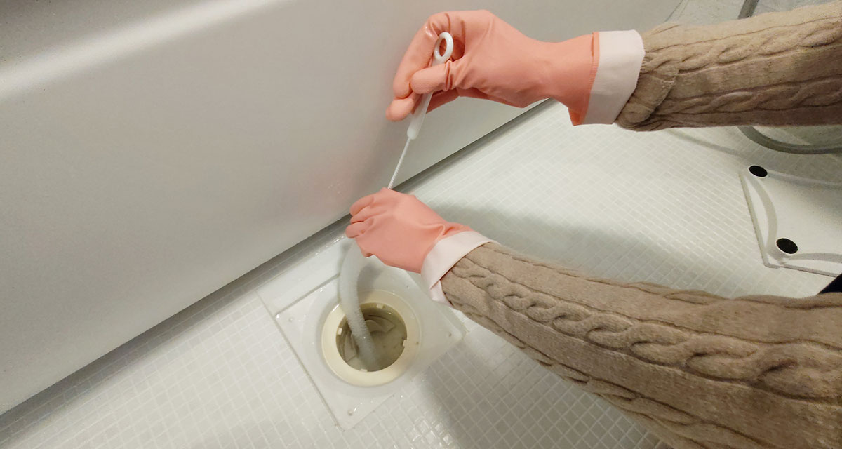 浴室の排水口を掃除している