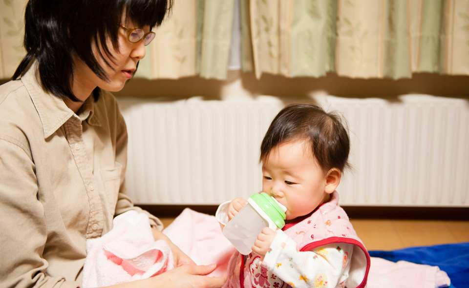 母親と水を飲む赤ちゃんの写真