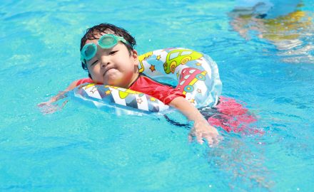 うきわに入って浮かんでいる男の子の写真