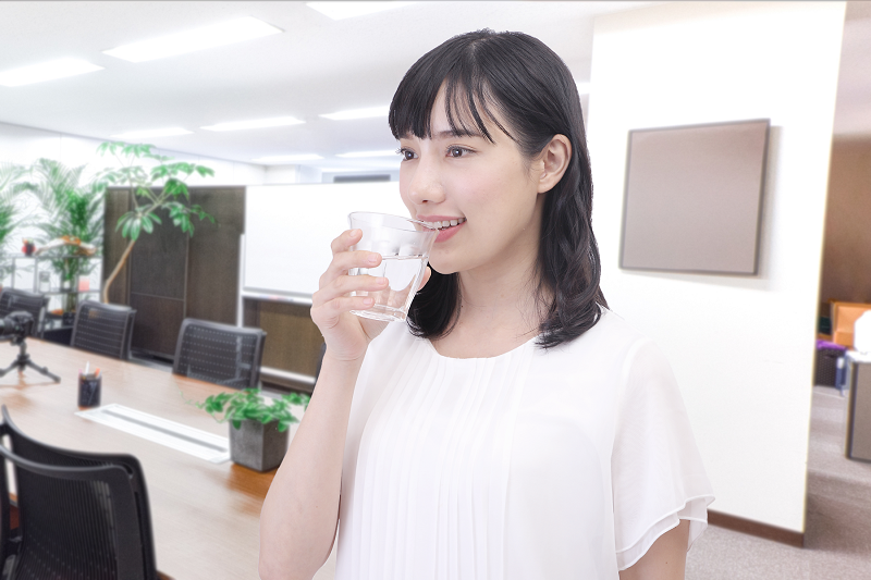 会社で水を飲んでいる女性の写真.